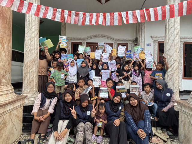 Anak-anak Desa Tambiluk menerima buku dalam kegiatan “Satu Anak Satu Buku” yang digelar KKM UNIBA Kelompok 41. Foto: Dok. KKM UNIBA Kelompok 41