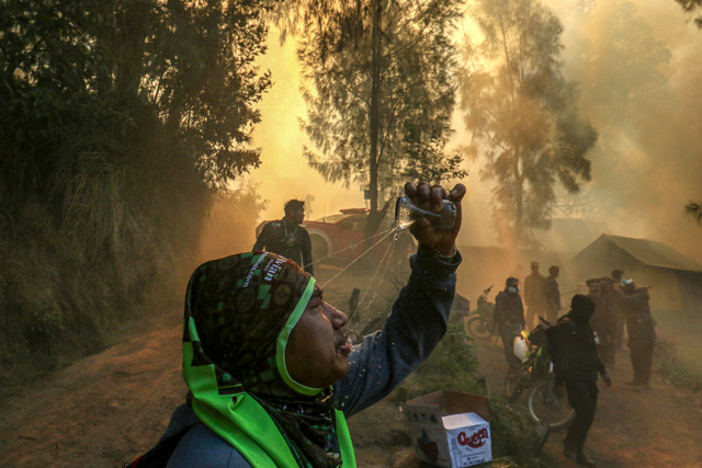 Petugas menyiram air ke mukanya usai memadamkan api yang membakar area jalur pendakian di Pos Bunder, Gunung Ijen, Banyuwangi, Jawa Timur, Jumat (4/9/2026). Foto: Budi Candra Setya/ANTARA FOTO