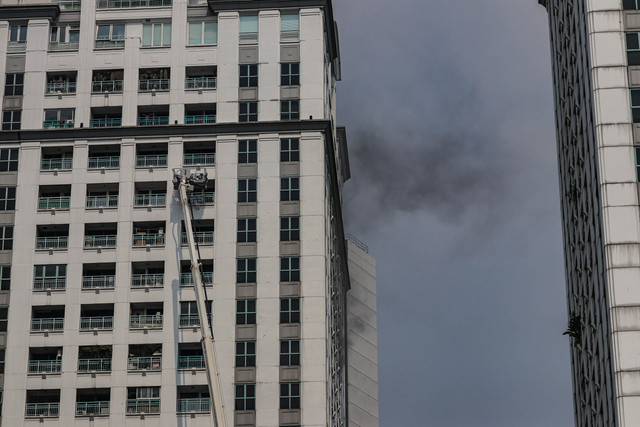 Petugas Suku Dinas Penanggulangan Kebakaran dan Penyelamatan (Gulkarmat) Jakarta Pusat berupaya mengevakuasi sejumlah penghuni yang terjebak saat kebakaran melanda Apartemen Pavilion di Jalan KH Mas Mansyur, Tanah Abang, Jakarta, Jumat (4/9/2026). Foto: Jamal Ramadhan/kumparan