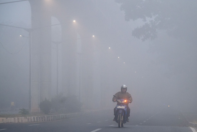 Warga berkendara menembus kabut asap di kawasan Jakabaring, Palembang, Sumatera Selatan, Sabtu (5/9/2026). Foto: Nova Wahyudi/ANTARA FOTO