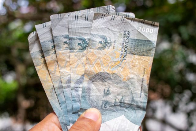 Foto oleh Ahsanjaya dari Pexels: https://www.pexels.com/id-id/foto/tangan-uang-memegang-kertas-8637071/
