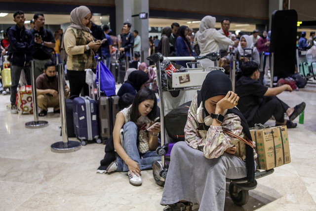 Calon penumpang berada konter lapor diri yang tutup di Bandara Soekarno Hatta, Tangerang, Banten, Minggu (6/9/2026). Foto: ABIMANYU / AFP