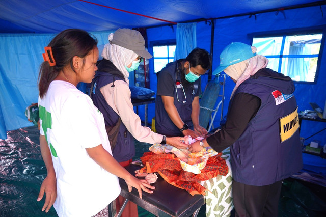 Tim Medis Darurat (EMT) Muhammadiyah sedang menangani pasien bayi di RS Lapangan, Dampek.