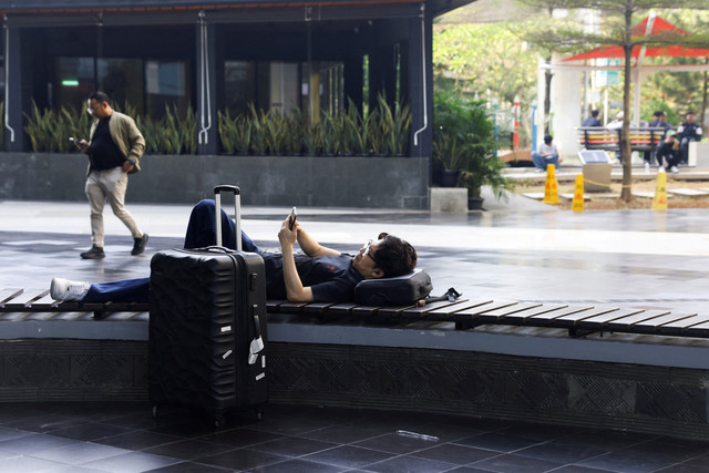 Penumpang yang terdampak pembatalan penerbangan imbas abu vulkanik Gunung Anak Krakatau beristirahat di Bandara Internasional Soekarno Hatta, Tangerang, Senin (7/9/2026). Foto: Ajeng Dinar Ulfiana/REUTERS