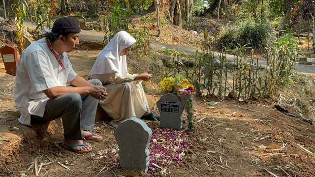 Ayah Mozza Axillia Gunarsa (17), Singgih Gunarsa dan adik Mozza saat berdoa di makam Mozza di Desa Gebugan, Bergas, Kabupayen Semarang, Senin (7/9/2026). Foto: Intan Alliva Khansa/kumparan