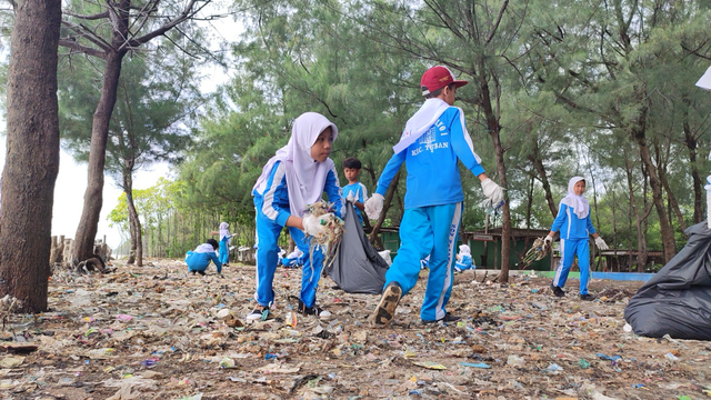 Siswa dan siswi SD Negeri Sarang Tiung, Kotabaru, Kalimantan Selatan bersama Pertamina International Shipping (PIS) melalui program Ocean LiteraSEA membersihkan sampah di pesisir pantai. Foto: Dok. Pertamina