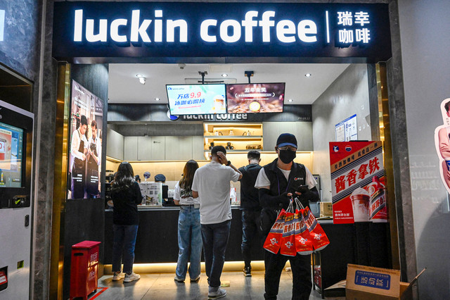 Pelanggan menunggu pesanan mereka di kedai kopi Luckin di Beijing pada 4 September 2023, saat perusahaan tersebut meluncurkan produk terbarunya hasil kolaborasi dengan merek minuman keras Tiongkok, Kweichow Moutai. Foto: Jade Gao/AFP