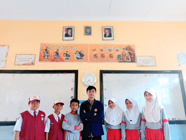 Mahasiswa Unesa Fadhil Insan Asmorondono bersama siswa-siswi SDN Tuwiri Kulon, Tuban, dalam kolaborasi pembuatan animasi pendek “Mental Korup”. Sumber foto: Dokumentasi pribadi