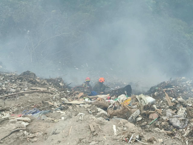 Petugas pemadam kebakaran saat berusaha memadamkan kebakaran lahan kosong yang digunakan sebagai tempat pembuangan puing di Kelurahan Ciumbuleuit, Kecamatan Cidadap, Kota Bandung, Selasa (14/9/2026). Foto: Abisatya/kumparan