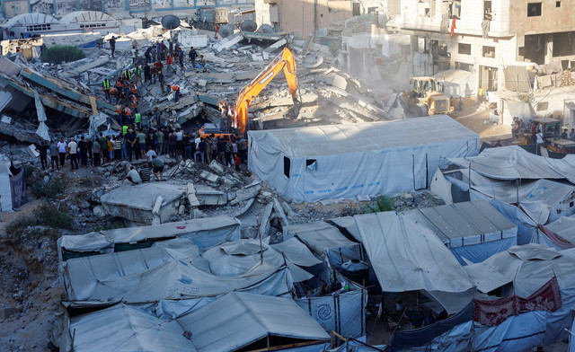 Petugas Pertahanan Sipil berupaya menyelamatkan orang-orang yang terjebak di bawah reruntuhan bangunan tempat tinggal yang rusak akibat serangan Israel sebelumnya di Kota Gaza, Rabu (16/9/2026). Foto: Mahmoud Issa/REUTERS