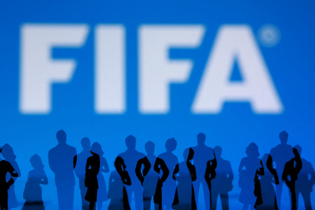 Logo FIFA dan siluet orang terlihat dalam sebuah ilustrasi. Foto: Dado Ruvic/REUTERS