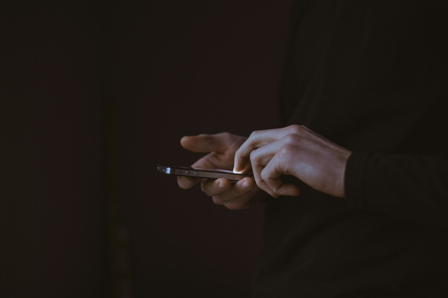 Keterangan: Ilustrasi seseorang memegang smartphone Sumber: Unsplash / Gilles Lambert