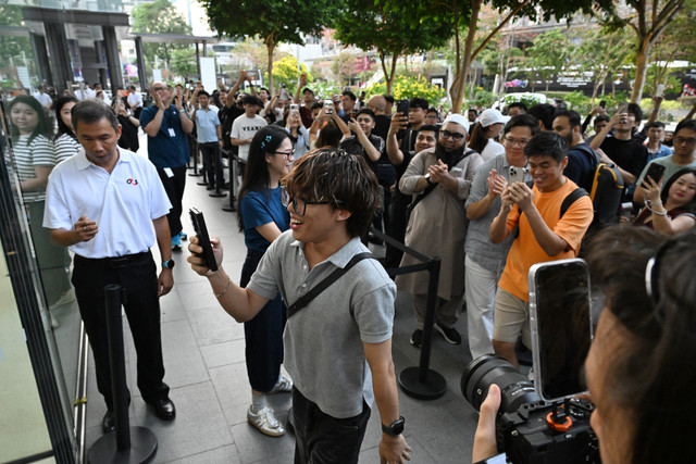 Orang-orang mengantre di luar toko Apple saat peluncuran seri iPhone 18 di Singapura, Jumat (18/9/2026). Foto: Roslan Rahman/AFP