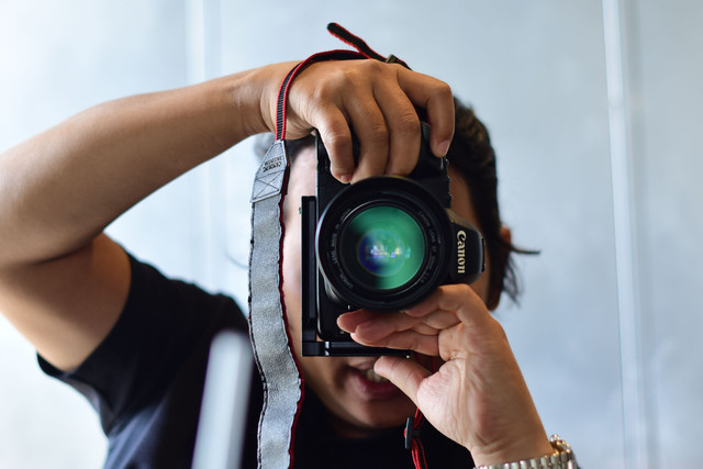 Foto oleh Sóc Năng Động: https://www.pexels.com/id-id/foto/fotografer-yang-memegang-kamera-dslr-di-dalam-ruangan-35558721/