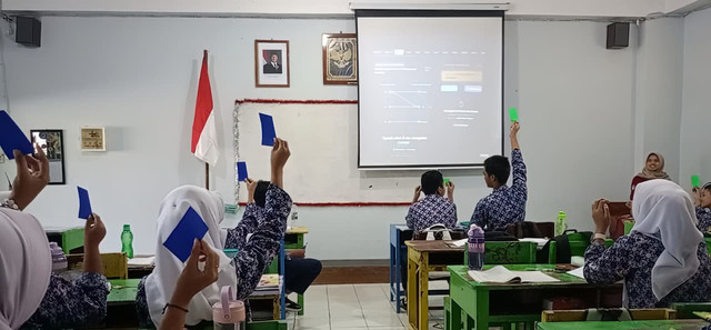 Peserta didik sedang mengangkat kertas origami untuk menunjukkan jawaban dalam permainan pilihan dan bertahan. Foto: Hanifatunnisa Amatulloh. Rabu (26/08/2026)
