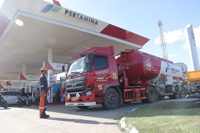 Seorang petugas terlihat berada di depan mengawal mobil tangki Pertamina. Foto: PPN