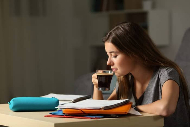 Anak muda yang meminum kopi ketika belajar atau beraktivitas