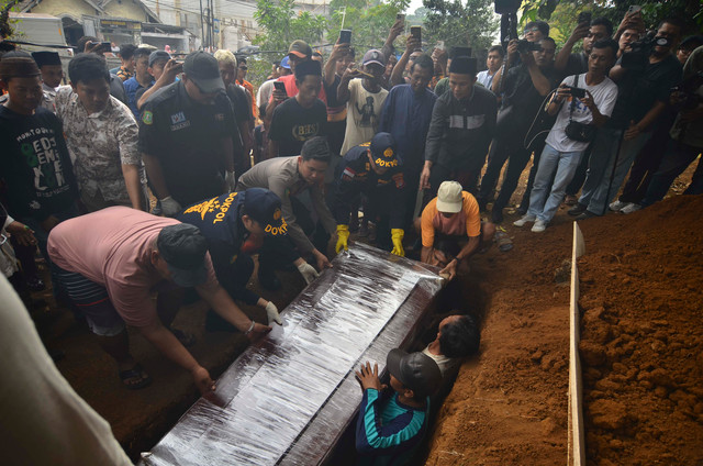 Polisi bersama kerabat memasukkan peti jenazah anak buah kapal (ABK) Arupadhatu 1, Surakman, ke dalam liang lahat di Tempat Pemakaman Umum (TPU) Ki Demang, Kampung Pagedongan, Carita, Kabupaten Pandeglang, Banten, Kamis (24/9/2026). Foto: Putra M. Akbar/ANTARA FOTO 