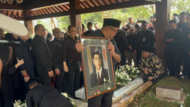Wakil Gubernur DKI Jakarta Rano Karno memegang foto almarhum Guruh Soekarnoputra di TPU Karet Bivak, Jakarta, Sabtu (26/9/2026). Foto: Kevin Daniel/kumparan