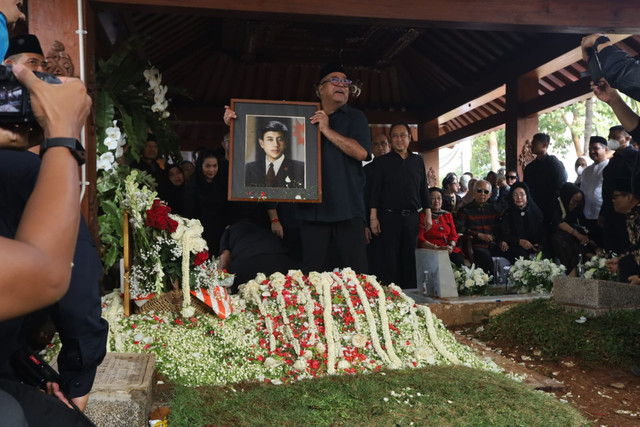 Wakil Gubernur DKI Jakarta Rano Karno memegang foto almarhum Guruh Soekarnoputra di TPU Karet Bivak, Jakarta, Sabtu (26/9/2026). Foto: Syawal Febrian Darisman/kumparan