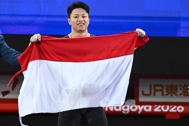 Lifter putra Indonesia Rahmat Erwin Abdullah memegang Bendera Merah Putih usai meraih medali emas pada final kelas 75 kilogram angkat besi Asian Games 2026 di Nagoya City Trade and Industry Center, Nagoya, Aichi, Jepang, Sabtu (26/9/2026). Foto: Fauzan/ANTARA FOTO