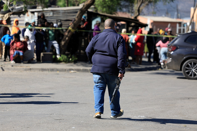 Seorang petugas polisi berjalan di lokasi penembakan di Lwandle, Western Cape, Afrika Selatan, Minggu (27/9/2026). Foto: Esa Alexander/REUTERS