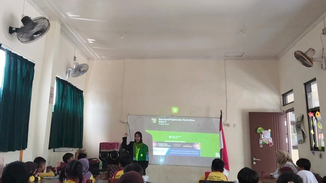 Mahasiswa Unesa Raya Desita Larasati memandu kuis Educaplay bertema huruf kapital dan tanda baca di kelas II SDN Buncitan. Sumber foto: Dokumentasi pribadi
