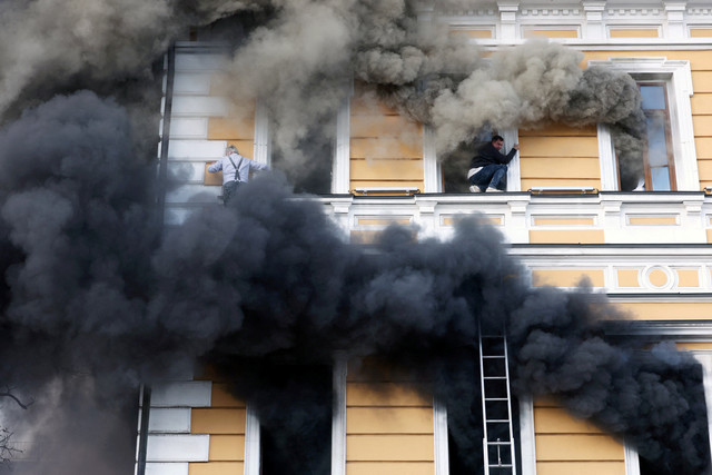 Warga berupaya mengevakuasi diri dari sebuah gedung yang terkena serangan drone di Kiev, Ukraina, Senin (28/9/2026). Foto: Alina Smutko/REUTERS