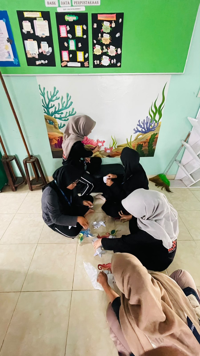 Mahasiswa Universita Ahmad Dahlan sedang melakukan penempelan hiasan untuk di beberapa dinding perpustakaan sekolah dasar Muhammadiyah, Karangploso, Kamis (10/8/2026). Foto: Syahda/Mahasiswa UAD