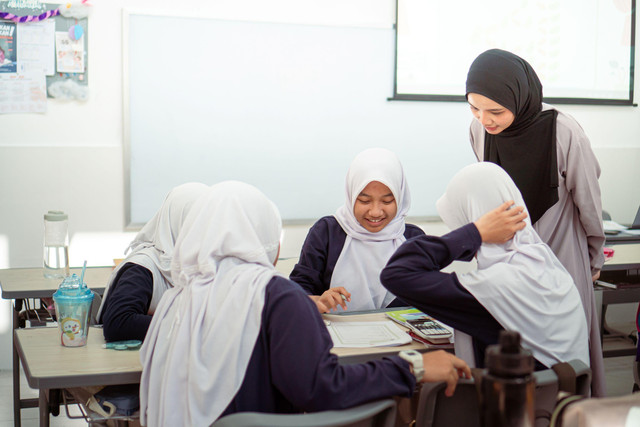 Guru mendampingi siswa dalam kegiatan pembelajaran di kelas.Foto: Irwan Zahuri/Pexels.
