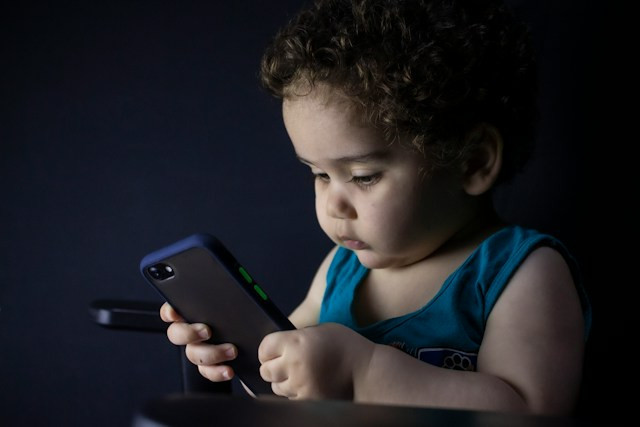 Anak kecil sedang memegang handphone, Foto: hessan nabavi
