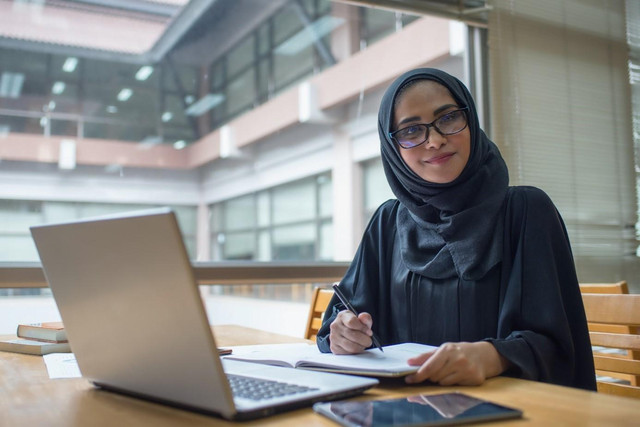Seorang perempuan berhijab sedang belajar menggunakan laptop.Foto: Pexels.