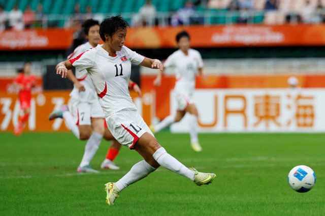 Pemain Timnas Wanita Korea Utara Jin Hong Han menendang bola ke arah gawang Timnas Wanita Korea Selatan pada pertandingan Asian Games 2026 di Stadion Shizuoka Ecopa, Fukuroi, Jepang, Senin (21/9/2026). Foto: Eloisa Lopez/REUTERS