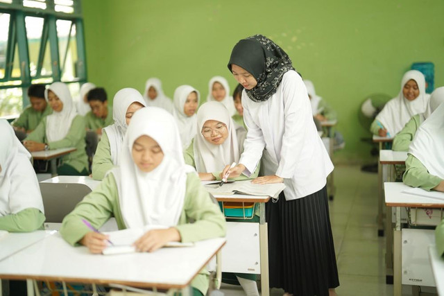 Guru sedang menjelaskan materi kepada siswa dalam kegiatan pembelajaran. Foto: [nama fotografer]/Pexels