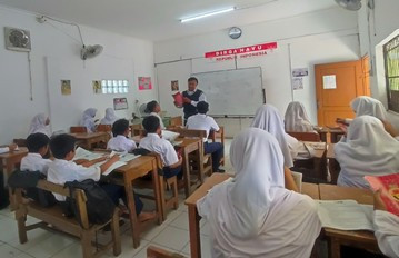 Suasana kegiatan belajar mengajar siswa SMP berseragam putih biru di kelas saat guru sedang menjelaskan materi. Foto: Dok. Pribadi.