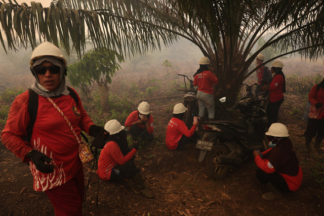 Anggota The Power of Mama beristirahat saat melakukan operasi pemadaman karhutla di perkebunan kelapa sawit Sungai Putri, Kabupaten Ketapang, Kalimantan Barat, Sabtu (29/8/2026). Foto: Willy Kurniawan/REUTERS
