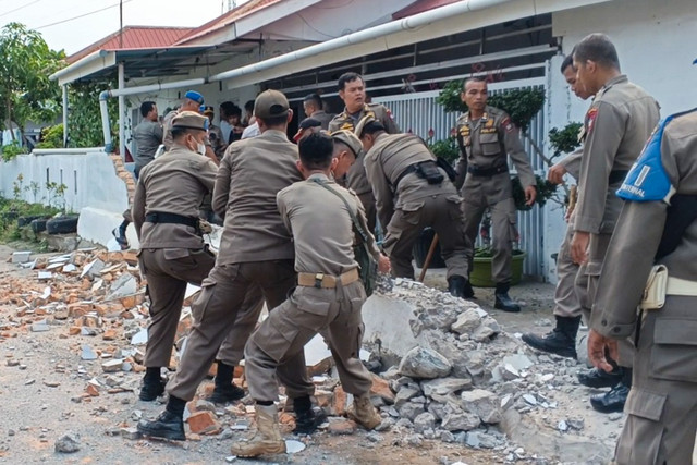 Personel Satuan Polisi Pamong Praja (Satpol PP) Kota Padang mendapat perlawanan saat menertibkan pagar tembok yang dibangun di atas badan jalan di kawasan Dadok Tunggul Hitam, Kecamatan Koto Tangah, Jumat (2/10). Foto:  Dok. Satpol PP Padang