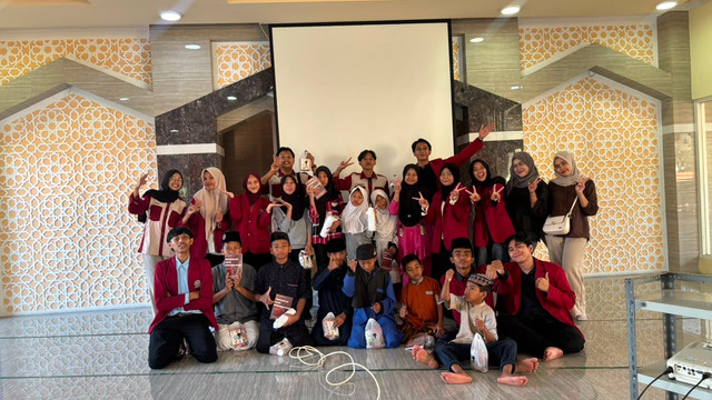 Kader IMM Yustisia Universitas Muhammadiyah Surabaya bersama anak-anak Panti Asuhan Muhammadiyah Cabang Tambaksari dalam kegiatan peluncuran buku Pendidikan Anak Berkemajuan, 23 Juni 2026. Sumber Foto: Dokumentasi Yustisia.