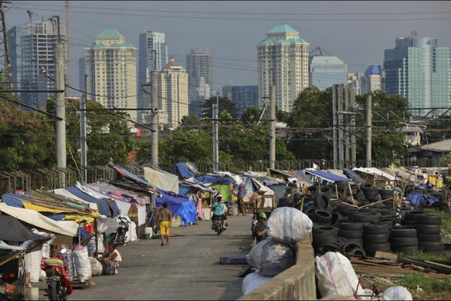 Gambaran pembangunan di Indonesia yang memperlihatkan gedung dan infrastruktur modern di tengah kehidupan masyarakat yang masih sederhana. Ilustrasi ini menggambarkan adanya perkembangan ekonomi dan pembangunan yang terus berjalan, tetapi di sisi lain masih terdapat masyarakat yang berjuang memenuhi kebutuhan hidup dan memperoleh kesejahteraan yang layak.Foto ilustrasi tersebut diambil dari Chatgpt.2026