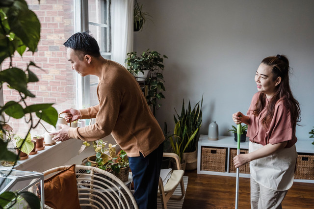 Sebuah pasangan yang merawat tanaman hias dan melakukan pekerjaan rumah. Foto: Pexels