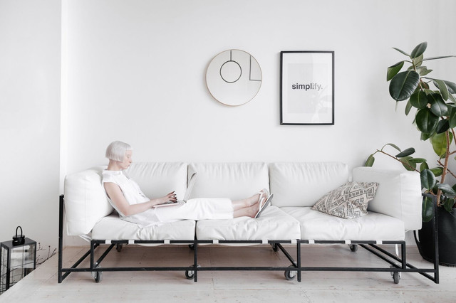 Ilustrasi seorang perempuan bersantai di sofa putih dalam ruangan dengan interior minimalis yang didominasi warna putih dan dekorasi sederhana. (Pexels/SHVETS production)