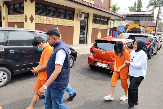 Dua pelaku pembuangan bayi di Sleman, sepasang kekasih berinisial VN (22, perempuan) dan FI (24, laki-laki) digiring di Polresta Sleman, Rabu (7/10/2026). Foto: Panji/kumparan