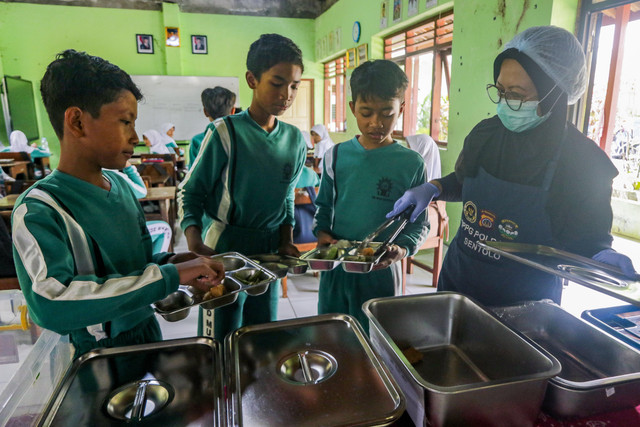 Petugas SPPG Polda DIY Sentolo memberikan lauk kepada siswa saat uji coba Program Makan Bergizi Gratis (MBG) dengan metode prasmanan di SD Muhammadiyah Bantar, Sentolo, Kulon Progo, DI Yogyakarta, Kamis (8/10/2026).  Foto: Rahid Putra Laksana/ANTARA FOTO