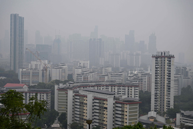 Sejumlah gedung bertingkat diselimuti kabut asap tebal di Singapura, Jumat (9/10/2026). Foto: Roslan Rahman/AFP