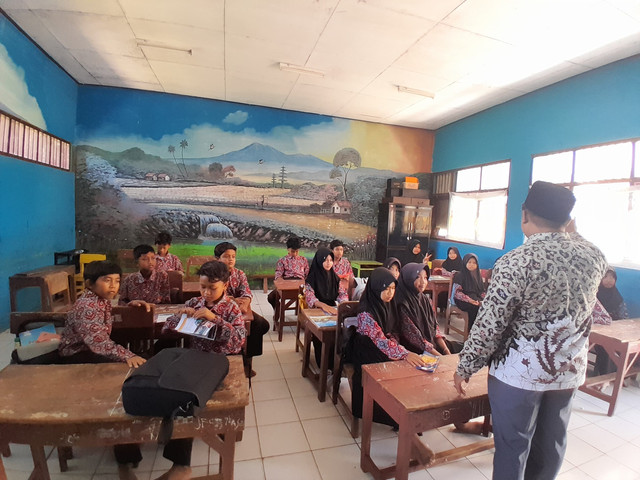 Guru sedang mendampingi siswa dalam proses pembelajaran di kelas. (Sumber: Samsul Arifin)