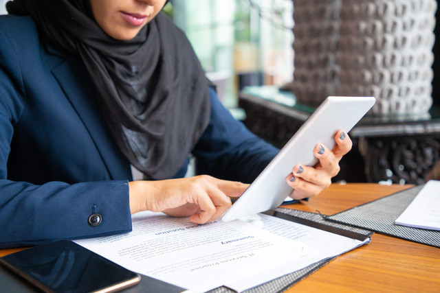 Foto: Ilustrasi seorang wanita bisnis membaca kontrak sambil berkonsultasi melalui internet. (pch.vector/Magnific)