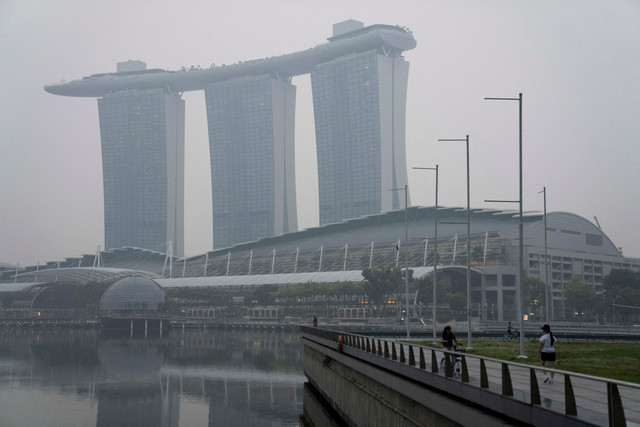 Kawasan Marina Bay Sands terselimuti kabut asap akibat kebakaran hutan di Indonesia, terlihat dari Singapura, Selasa (13/10/2026). Foto: Kokkai Ng/REUTERS