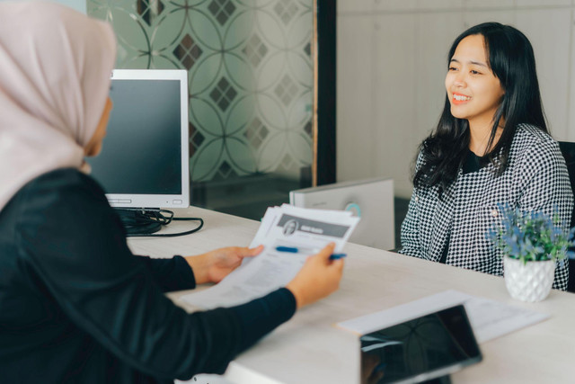 Kandidat sedang diwawancarai perekrut sambil membahas CV. Sumber: Shutterstock.