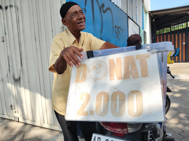 Kakek Bambang berjualan donat dengan sepeda motor Honda Supra X kesayangannya di Jalan Timoho, Kota Yogyakarta, Rabu (14/10/2026). Foto: Arfiansyah Panji Purnandaru/kumparan