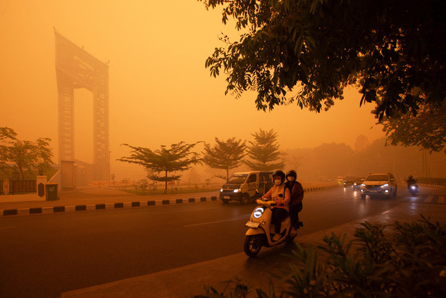 Pengendara berkendara melintasi jalan saat kabut asap kebakaran hutan menyelimuti kawasan Palangka Raya, Kalimantan Tengah, Rabu (14/10/2026). Foto: REUTERS/Arief Rahman Septian Prathama